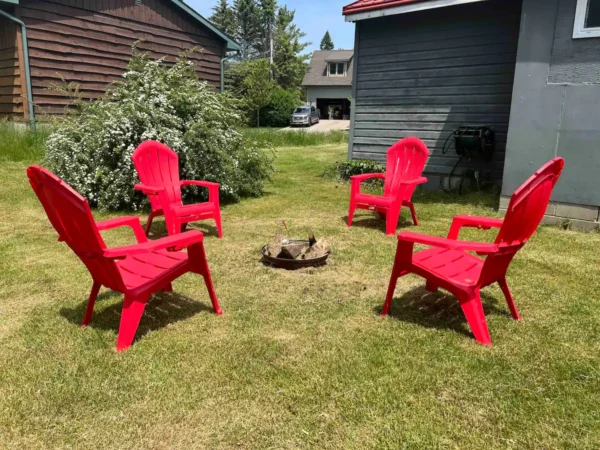 A group of red chairs sitting in the grass.