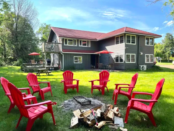 A group of red chairs around a fire pit.